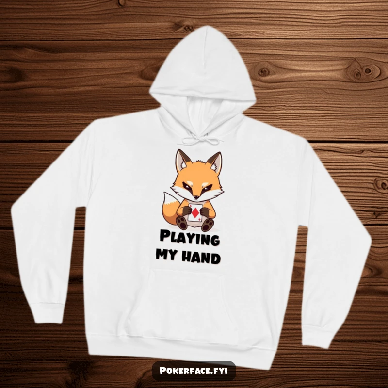 Funny hoodie depicting a stoic fox character with a blank expression, intently playing a card, perfect for cozy, contemplative moments.